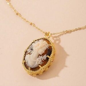 Gold cameo broach with amber brown background